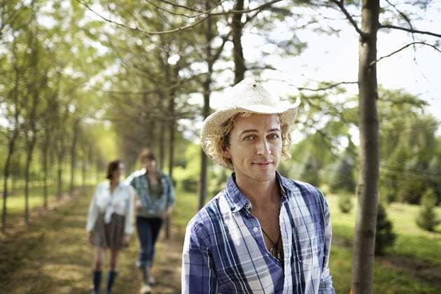 IMAGO Creative: Landleben - Alfresco, Draußen A group of friends walking down an avenue of trees in woodland. 