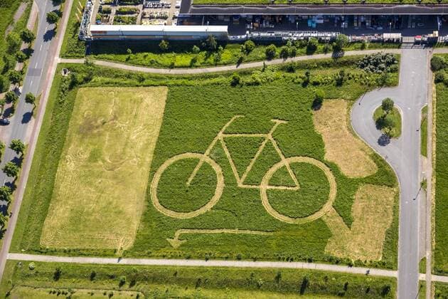 Ökozentrum Hamm mit einem großen eingemähtem Fahrrad hinter OBI, Rasenkunst und Reklame für ein Fahrradgeschäft, Hamm, Ruhrgebiet, Nordrhein-Westfalen, Deutschland !ACHTUNGxMINDESTHONORARx60xEURO!