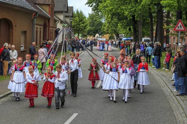 Sorbisches Folkloreensemble Schleife DEU Sachsen Schleife Â Das Kirchspiel Schleife liegt zwischen Ober- und Niederlausitz und gehört zu den vier sorbischen Trachtenregionen, in denen die Tracht auch heute noch im Alltag getragen wird. Es ist Deutschlands einzige Region in der das Spiel auf dem Dudelsack seit Jahrhunderten ununterbrochen stattfindet. Der sorbische Dudelsack ist in seinen Ausmaßen der größte der weltweit existierenden Dudelsackarten und wird ohne Naht aus einem Ziegenfell, im Ganzen hergestellt. Seit mehreren Jahren findet in Schleife ein internationales Dudelsackfestival statt. Besonderen Stellenwert gewinnt das Festival, weil die Sorben mit ihrer Sprache, ihren Bräuchen, Trachten und Traditionen eine Brücke zu Osteuropa bilden. Im sorbischen Kirchspiel Schleife, an der Grenze zu Brandenburg, hat sich ueber die Jahrhunderte eine eigene Trachtenform entwickelt.