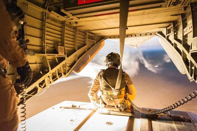 Ein Soldat der Bundeswehr sitzt am 10.07.2014 auf dem Flug von Camp Marmal der Bundeswehr bei Mazar-e Sharif in Afghanistan nach Camp Shaheen auf der offenen Ladefläche eines CH-53 Helikopter während dieser Flairs abfeuert. Flairs sind Hitzefackeln die Raketen vom eigentlichen Ziel ablenken sollen.