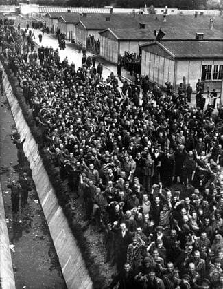 IMAGO History, Zweiter Weltkrieg: 1939 - 1945 Oct. 5, 1945 - Dachau, Bavaria, Germany - Dachau, the most infamous concentration camp of all has been liberated by men of the 42nd Rainbow Division of the U.S. 7th Army. Scenes of appalling horror were witnessed by the American troops as they went from building to building. Thousands of starved corpses were piled nearly to the roof awating cremation. Pictured: Political prisoners cheer madly as they hear the guns of the 42nd Rainbow Division getting louder and louder on the approach to Dachau. Dachau Germany  - ZUMAk09