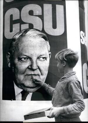 Aug. 08, 1965 - A cigar for Federal Chancellor Prof. Ludwig Erhard: The little boy was sent by his father for getting cigars, and on the way home he suddenly discovered this election-bill of the CSU . But the little boy knows the Chancellor only with a cigar. For on this placard no cigar was to see in the Chancellors hands he tried to make the usual view of Prof. Ludwig Erhard o.k.  - ZUMAk09