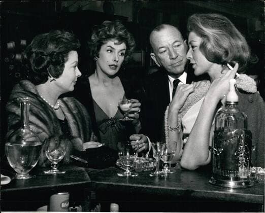 Jan. 29, 1959 - 29.1.59 The lucky squire of London town Noel Coward escorts three fascinating women Mr. Noel Coward was surely the luckiest man in London last night, when, beaming like a benevolent sultan he escorted three of the world s most fascinating women, Kay Kendall, Vivian Leigh and Lauren Bacall, to the St. Martin s Theatre. They went to see The Grass is Greener starring their mutual friend, Celia Johnson. The party had been laid on by Vivian Leigh. Photo Shows: During the interval Noel takes the trio for a drink and here he is chatting at the bar to (L to R) Vivian Leigh, Kay Kendall and Lauren Bacall.  - ZUMAk09