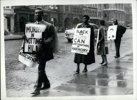 Jun. 06, 1959 - Coloured People Hold Protest Walk In Whitehall: A small band of coloured men and women were to be seen holding a demonstration in Whitehall today - carrying posters, which include a drawing of Kelso Cochrane, murdered in Notting Hill last month. They are members of the Coloured People s Progressive Association. Photo shows Some of the coloured people during their walk in Whitehall this morning.  - ZUMAk09