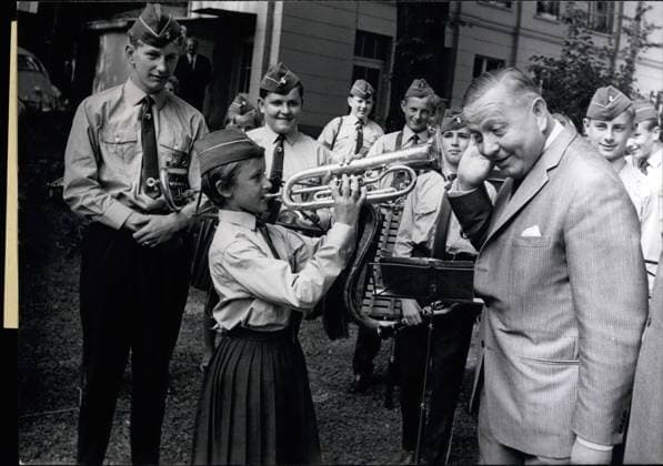 Jul. 07, 1964 - A Serenade for the Minister Like a star Monika Hausnar 11, falt, when she brought Minister Alois Niedrealt a serenade together with the Stiftslander Musicians. Althrough Monika is a girl she is a member of the brass band. We are Colleagues Minister Alois Niederalt told her as I liked too to play a wind instrument when i was young.  - ZUMAk09