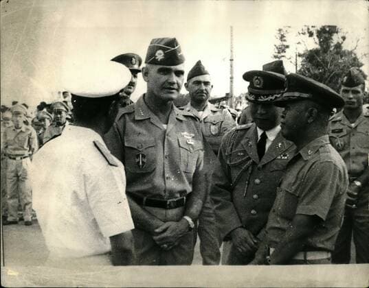 Mar. 03, 1965 - The Battle For Power In Saigon South Korean Troops Arrive In Vietnam: Lieut. Gen. Nguyen Khanh turned over command of South Vietnam s armed forces to Major Gen. Tran Van Minh in ceremonies at the Joint General Staff Headquarters in Saigon. Khanh has been named Ambassador at Large. During the ceremonies a contingent of South Korean soldiers arrived in Saigon. Photo shows U.S. Military Commander General William C. Westmorland chats with Vietnamese soldiers in Saigon.  - ZUMAk09
