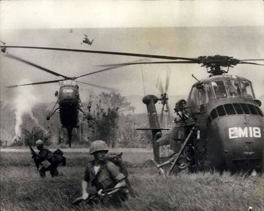 IMAGO History, Vietnamkrieg: 1955-1975 Mar. 25, 1966 - The War In Vietnam -Helicopter Land Troops In Operation Against The Viet Cong: Phot shows U.S. troops find themselves waist high in Swampy fields as they jump the helicopters which have carries them into action against the Viet Cong. Over 400 troops took part in the raid to clean but smoke is from a phosphorous rocket used as a landing marker by an observation Bird Dog plane.  - ZUMAk09