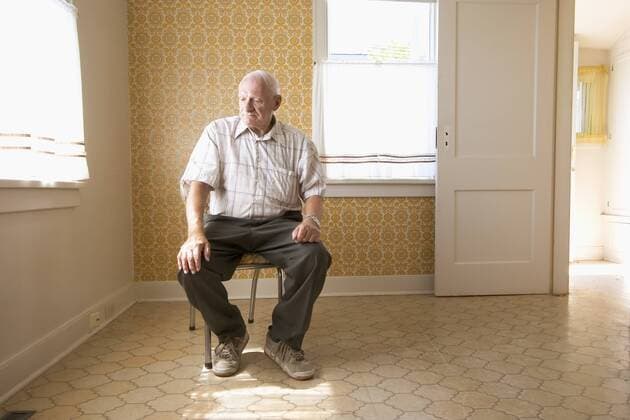 senior citizen (70-80 years old) sitting on chair in vacant house, Canada.  acp05758 RoyxOoms