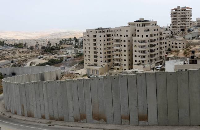 An view of the Israeli separation wall surrounding the Shuafat Refugee Camp in the West Bank, September 28, 2014. Palestinian President Mahmoud Abbas accused Israel of causing the American peace initiative to fail by continuing settlement building, land confiscations, home demolitions and strangling the Palestinians by occupation during negotiations in his speech to the U.N. General Assembly on Friday.  JER2014092821