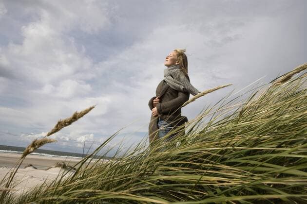 Germany, Schleswig Holstein, Amrum, Young woman on grassy sand dune model released  RBF00020