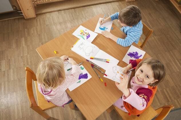 Germany, Children in nursery sitting at table drawing pictures, elevated view model released property released  RNF00221