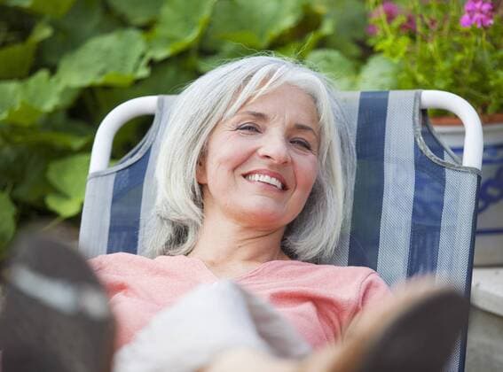 IMAGO Creative: Landleben - Alfresco, Draußen Germany, Bavaria, Mature woman sitting in lawn chair model released property released  HSIYF000075