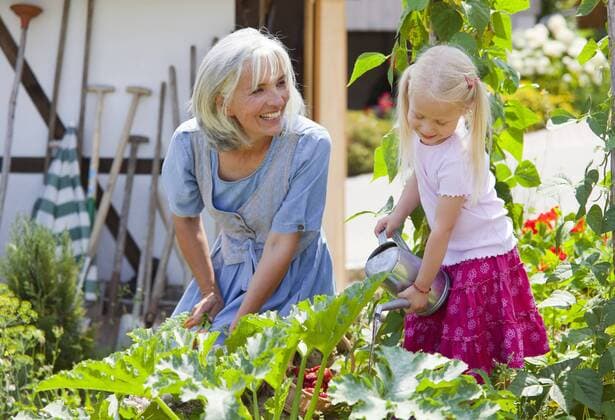 Germany, Bavaria, Mature woman and girl in graden caring for plants model released property released  HSIYF000132