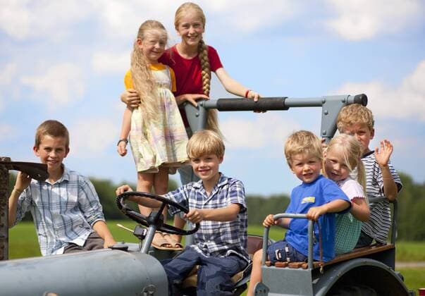 Germany, Bavaria, Group of children sitting in old tractor model released property released  HSIYF000159
