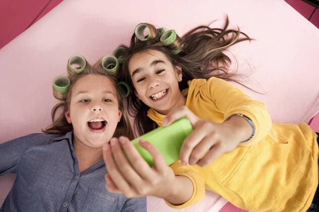 Girls with hair rollers photographing self with smartphone model released  RNF001076