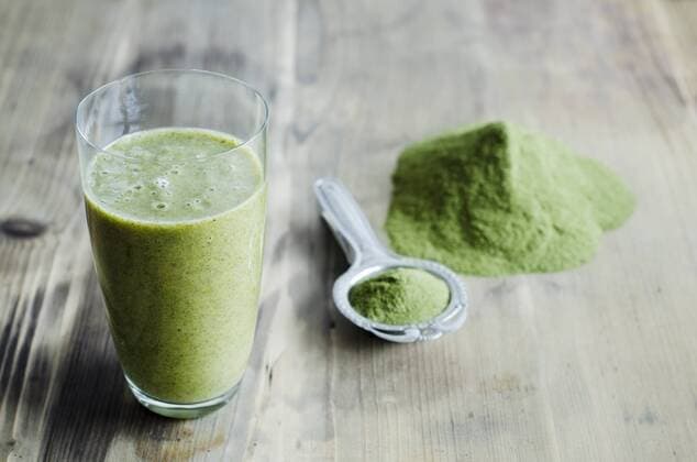 Moringa powder on spoon and wooden table and glass of moringa smoothie  CZF000133