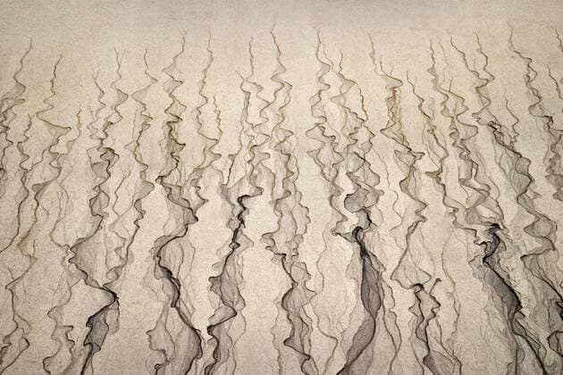 Meer; Küste; Strand; Sand; Sandspuren; Sandmuster; Sandstruktur: Rinnsaale hinterlassen Struktur am Sandstrand