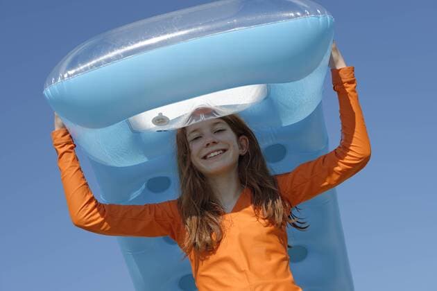 IMAGO Creative, Jahreszeit Sommer, Sonnenschutz Portrait of smiling girl carrying air mattress on her head wearing sun protection longsleeve model released Symbolfoto  LBF000834