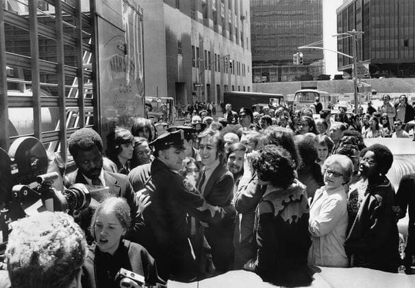 New York, New York: May 12, 1972 John Lennon and Yoko Ono get an assist from a policeman as they try to work their way through the crowd after leaving the Immigration Office on Broadway. 990_16_X-Beatles_2HR