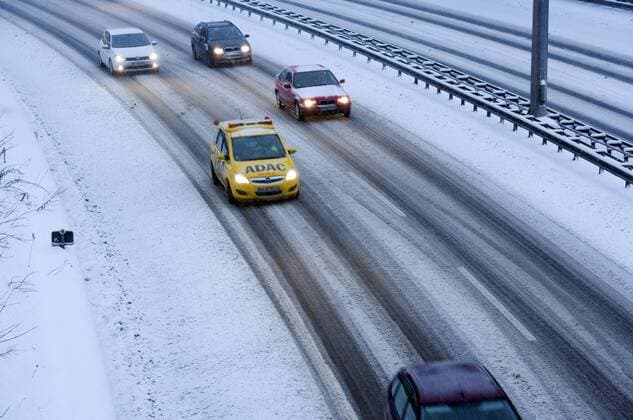 Gelber Engel im Schnee DEU, Deutschland, Berlin, 2010-01-09: Pkw im Schneetreiben auf der AVUS in einer Kurve in Berlin-Nikolassee. Die Fahrbahnen sind noch nicht geraeumt. Im Pulk der Fahrzeuge ein Gelber Engel genannter Pannenhelfer des ADAC.