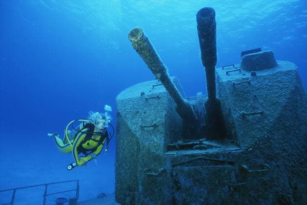 Diver examines cannons on wreck of Russian missile frigate, Destroyer 356, renamed MV Capt Keith Tibbets, Cayman Islands, Caribbean  1150731 DougxPerrine