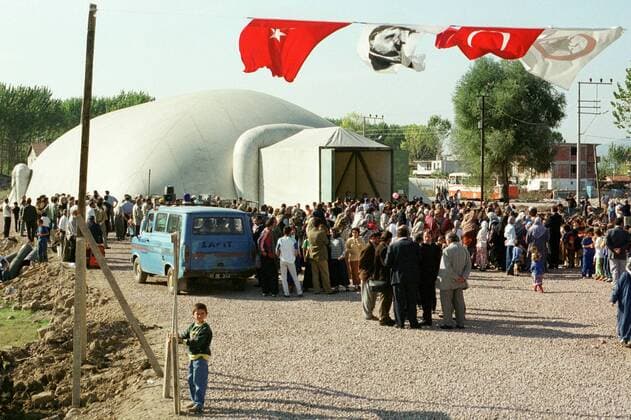 Tuerkei Leben nach dem Erdbeben 1999 Nach dem Erdbeben im August in der Tuerkei leben tausende Menschen in Zeltlagern und Behilfszelten. Die Hilfsorganisation Kinder haben Rechte hat in der Ortschaft Yuvacik-Koey eine Traglufthalle aufgebaut, die fuer die Kinder als Schulhaus dienen soll, da nicht klar ist, ob und wann die Regierung ein neues Schulhaus errichtet. Hier: Kinder aus dem Ort und der Umgebung sind zur Eroeffnung ihrer Ballon-Schule gekommen. 14.10.1999, Yuvacik-Koey Tuerkei
