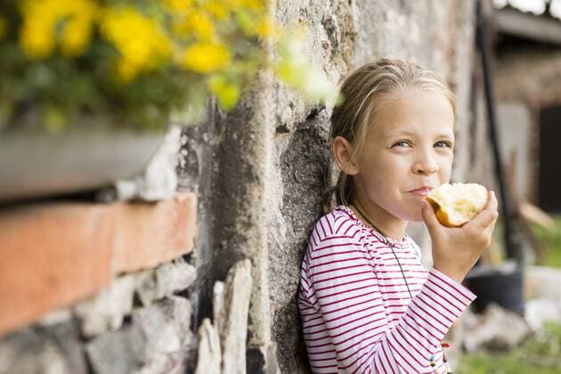 Portrait of smiling little girl eating an apple model released Symbolfoto  FKIF000047