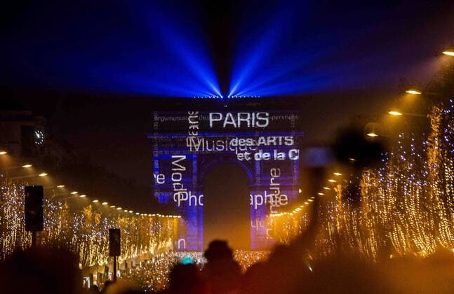 People watch the light show fireworks over the Arc de Triomphe as they celebrate the New Year s Eve on the Champs Elysees avenue in Paris, France, Dec. 31, 2014. ) (lyi) FRANCE-PARIS-NEW YEAR-CELEBRATION CHENxXIAOWEI 