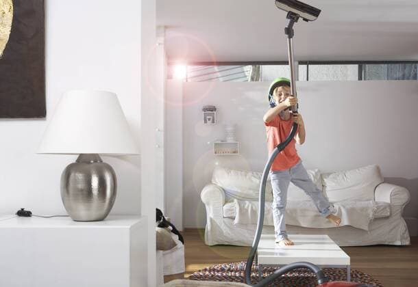 Boy in living room hoovering the ceiling model released Symbolfoto property released  FSF000273
