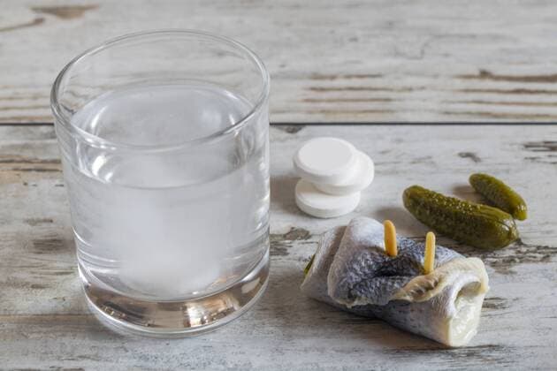 Rollmops, pickled cucumbers, glass of water and fizzy tablets on wood  SARF001188