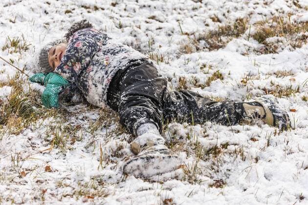 Little girl lying on snow covered meadow model released Symbolfoto  TCF004477