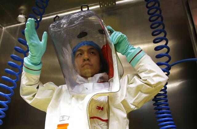 (150131) -- WUHAN, A researcher puts on a protective suit before entering the newly-completed lab in Wuhan, capital of central China s Hubei Province, Jan. 30, 2015. China completed its first high level biosafety laboratory based in Wuhan Saturday in Wuhan after more than a decade of construction. The lab will be used to study class four pathogens (P4), which refers to the most virulent viruses that pose a high risk of aerosol-transmitted person-to-person infections. ) (wyo) CHINA-WUHAN-BIOSAFETY LAB (CN) YinxGang 