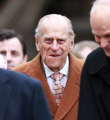 West Newton, Norfolk, UK . . 01.02.2015 Prince Philip, Duke of Edinburgh smiles broadly as they make their way to St. Peter and St. Paul Church for Sunday morning service in West Newton. 
