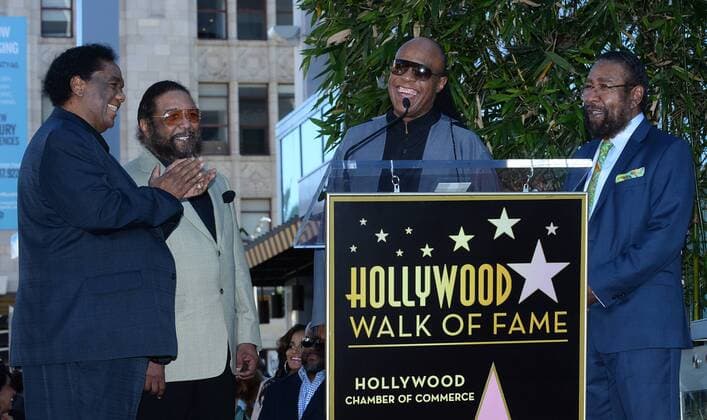 Songwriters Lamont Dozier, Eddie Holland and Brian Holland (L-R) react to comments by Stevie Wonder (C) during an unveiling ceremony honoring them with the 2,543rd star on the Hollywood Walk of Fame in Los Angeles on February 13, 2015.  LAP2015021307 JIMxRUYMEN