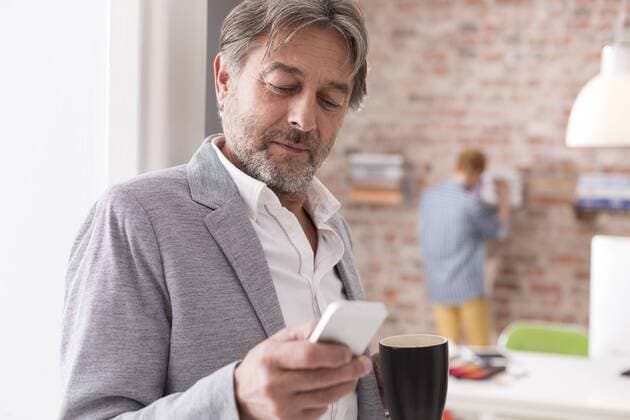 Businessman with cell phone and cup of coffee in office model released Symbolfoto property released  WESTF020525