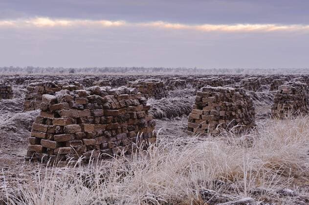 IMAGO Nature: Unsere Erde, Ressourcen, Torf endlose Stapel von Torfballen beim Torfabbau im von Raureif ueberzogenen Goldenstedter Moor, Deutschland, Niedersachsen, Goldenstedt endless stacks of bales of peat at the peat extraction at the Goldenstedter Moor covered with hoar frost, Germany, Lower Saxony, Goldenstedt BLWS312612