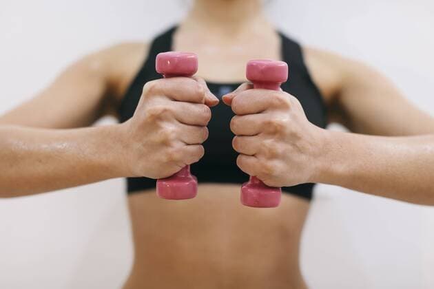 Hands of woman holding dumbbells model released Symbolfoto  EBSF000427
