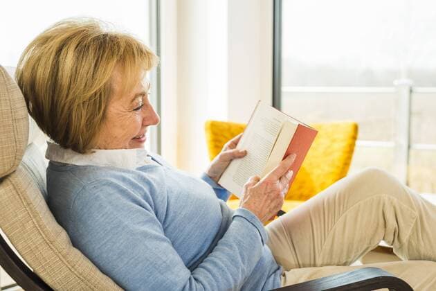 Senior woman at home reading book model released Symbolfoto property released  UUF003472