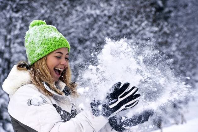 gutgelaunte huebsche junge Frau wirft Schnee in die Luft, Frankreich, Savoy cheerful good looking young woman throwing up snow , France, Savoie BLWS390855