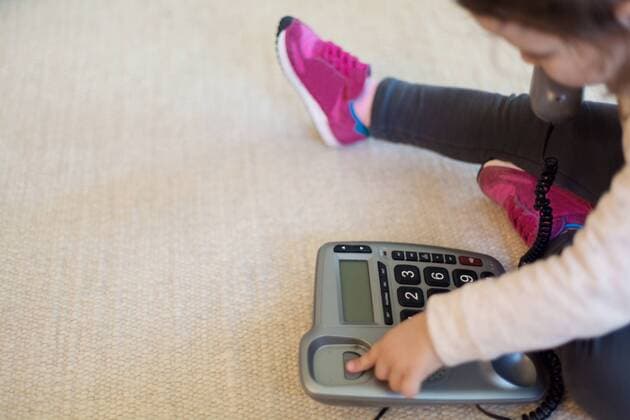 Little girl playing with telephone while sitting on carpet model released Symbolfoto  LSF000020