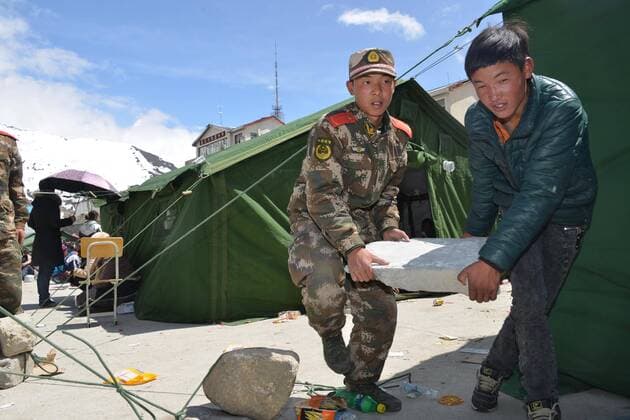 (150426) -- XIGAZE, April 26, 2015 -- People set up makeshift tents at a middle school in Nyalam County in Xigaze, southwest China s Tibet Autonomous Region, April 26, 2015. Death toll in southwest China s Tibet Autonomous Region from the earthquake that struck neighboring Nepal on Saturday has climbed to 18. A total of 55 people there were injured, according to the regional disaster relief headquarters. ) (yxb) CHINA-TIBET-NEPAL EARTHQUAKE (CN) ZhangxQuan 