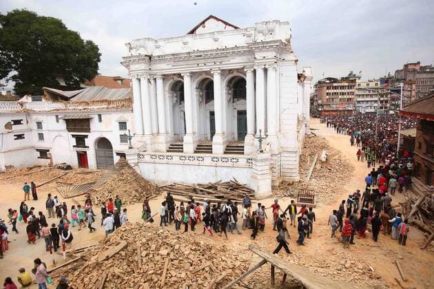 Nepalese and rescue members gather around the collapsed Darahara Tower in Kathmandu in Nepal, on April 25, 2015. New tremors sent shocked survivors scurrying outdoors just 24 hours after a devastating 7.9 magnitude earthquake shook the region which so far has taken the lives of at least 2,500 people.  NEP2015042603 SanjogxManandhar