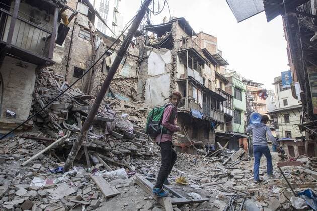KATHMANDU, NEPAL - APRIL 26: (CHINA OUT) Two man pass by the ruins on April 26, 2105 in Kathmandu, Nepal. A 8.1-magnitude earthquake struck Nepal on Saturday and the earthquake felt in southeast China s Tibet Autonomous Region which brought some houses into collapse. While another 7.1-magnitude earthquake hit the county again the following day afternoon. Chinese government sent out Sichuan Rescue Team, the only one national emergency medical rescue team who could settle camps above an altitude of 3500 meters, to Nepal to support local rescue work and international assistance were also sent to the disaster areas. The earthquake had caused at least 3218 people to death and parts of Chinese visitors were detained in Nepal by Monday morning.  CFP466626282