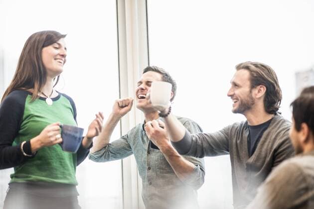 Four work colleagues on a break, laughing and raising their coffee cups. Four work colleagues on a break, laughing and raising their coffee cups.  15998