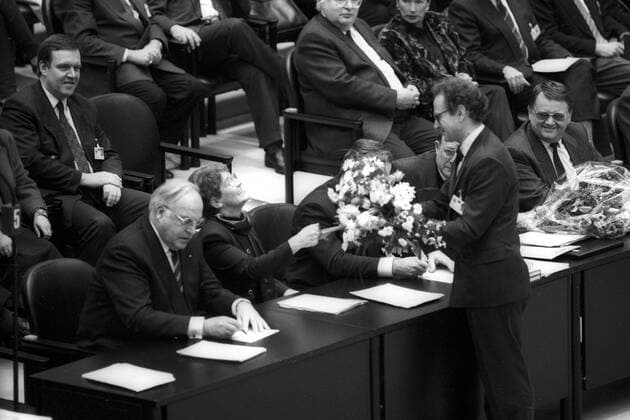 Konstituierende Sitzung des ersten gesamtdeutschen Bundestages im Reichstagsgebäude in Berlin - Rita Süssmuth erhält einen Blumenstrauß nach ihrer Wahl zur Bundestagspräsidentin - li.: Helmut Kohl, hinten: Volker Rühe