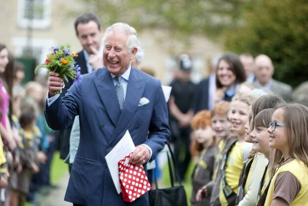Prince Charles the Prince of Wales is pictured arriving at Fairford Church in Gloucestershire, where he is attending the Music in the Churches concert. The prince looks delighted with a bunch of flowers presented to him by some Brownies on his way to the church. MAY 23rd 2015  RWNx151646