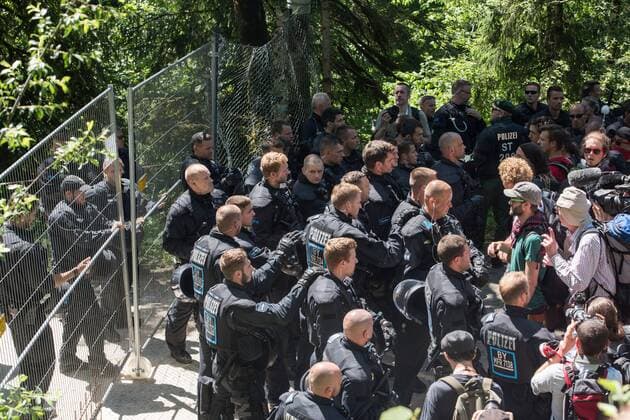 G7-Gipfelgegner stehen am Sonntag (07.06.15) von dem Schutzzaun, der weitlaeufig um das Schloss Elmau in den Bergen von Garmisch-Partenkirschen gezogen wurde. Etwa 400 Gipfelgegner sind am Sonntag von Garmisch-Partenkirchen Richtung Elmau gegangen, um gegen das Treffen der G7-Staaten zu protestieren. Beim G-7-Gipfel am Sonntag und Montag auf Schloss Elmau bei Garmisch-Patenkirchen sind mehr als 20.000 Polizisten im Einsatz. Bundeskanzlerin Angela Merkel (CDU) empfaengt die Staats- und Regierungschefs der USA, Kanadas, Frankreichs, Grossbritanniens, Italiens und Japans. G7-Gipfelgegner gehen nach Elmau Copyright: epd-bild ThomasxLohnes EDITORIAL USE ONLY
