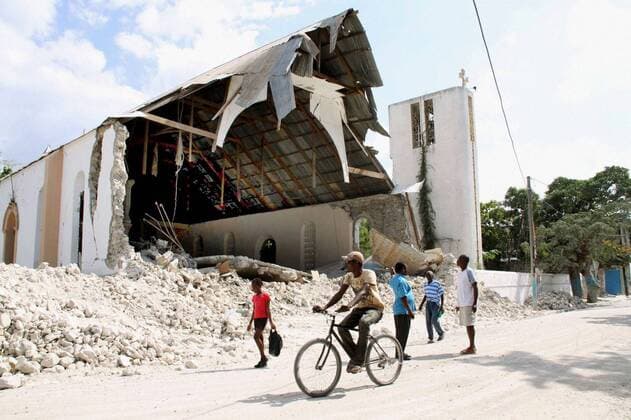 GRAND-GOAVE, Haiti - People walk past a collapsed church in Grand-Goave, a quake-devastated Haitian fishing village, on Jan. 31, 2010. More than 80 were killed and more than 500 have been displaced by the recent earthquake in the village, 50 kilometers west of Port-au-Prince.  0201055
