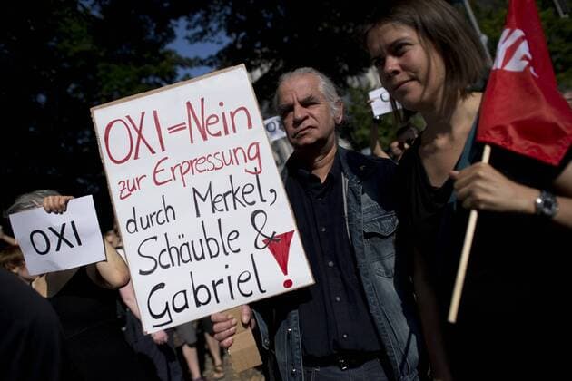 Protest Bundestag Griechenland-Sondersitzung DEU, Deutschland, Germany, Berlin, 17.07.2015 Protestler mit Plakat OXI Nein zur Erpressung durch Merkel und Schaeuble und Gabriel beim Protest der Partei Die Linke, Linkspartei, gegen die Sondersitzung zum Hilfspaket fuer Griechenland vor dem Deutschen Bundestag im Regierungsviertel in Berlin. Die Demonstranten ueben Solidaritaet mit Griechenland und sprechen sich gegen die Austeritaetspolitik, gegen einen Grexit und Schuldenpolitik der Bundesregierung aus. Activist holds a banner No to OXI and against Merkel, Schaeuble and Gabriel, Fair Play with Greece during a rally in front of the German Parliament Deutscher Bundestag in Berlin. The demonstration shows solidarity with the finance crises in Greece. It is also a protest against German government s policy towards Greece and a possible Grexit.