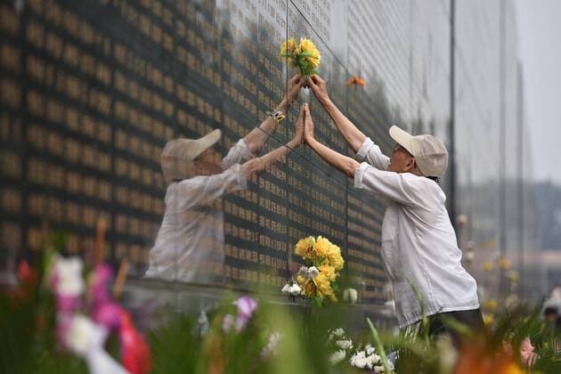 A resident pastes a paper flower beside the name of his relative dead in the 1976 Tangshan earthquake in front of the memorial wall in Tangshan, north China s Hebei Province, July 28, 2015. Local residents came to the memorial park on Tuesday to commemorate the 39th anniversary of the Tangshan earthquake. )(mcg) CHINA-HEBEI-TANGSHAN-COMMEMORATION (CN) LixJunyi 